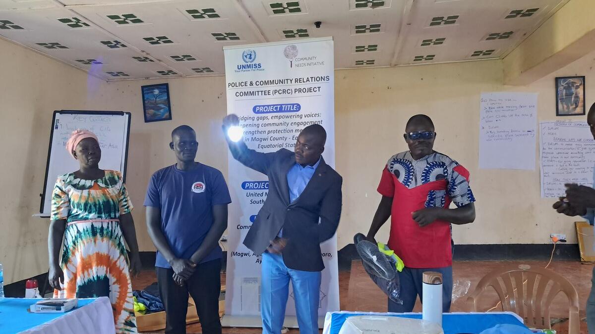 A group of people stand indoors during a UNMISS community workshop.