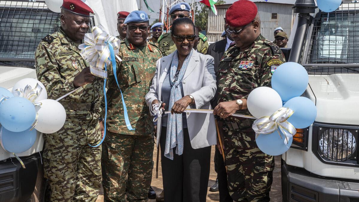 Valentine Rugwabiza tient des ballons avec des casques bleus. 
