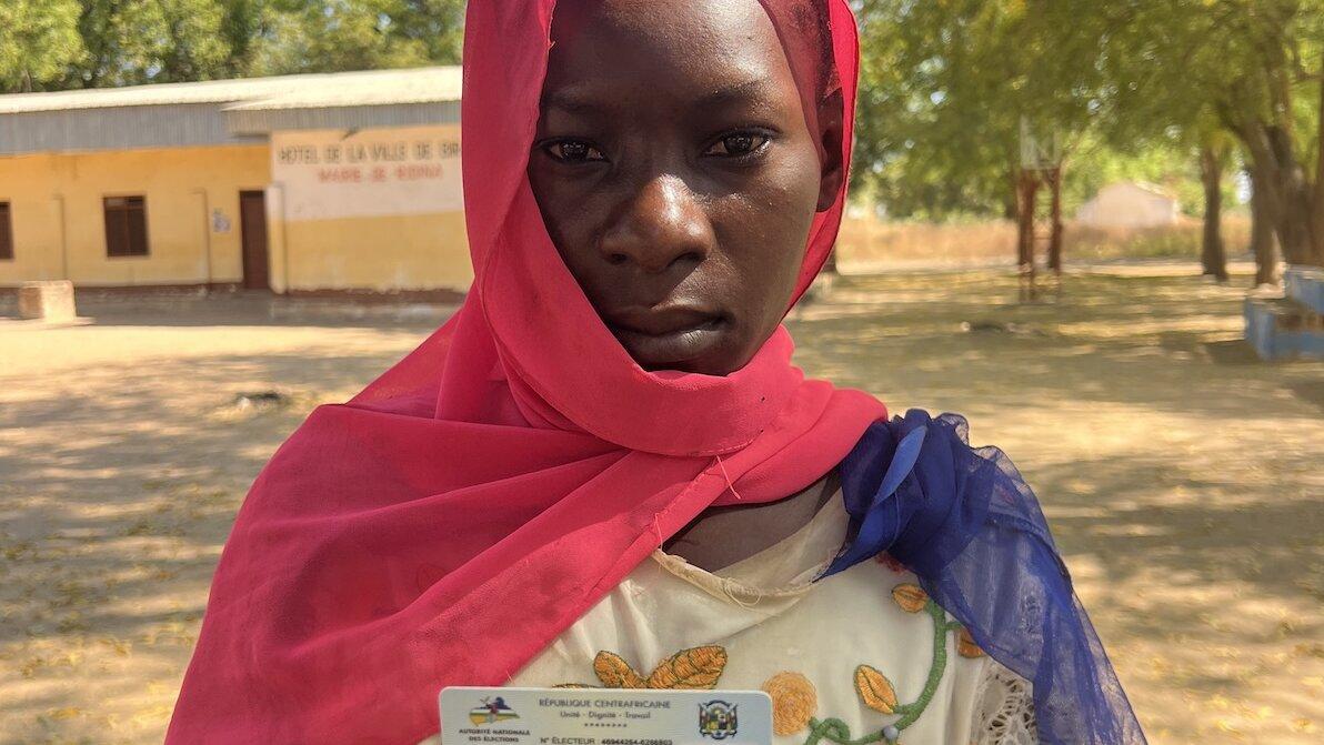 Un électeur pose pour une photo avec sa carte d’identité.