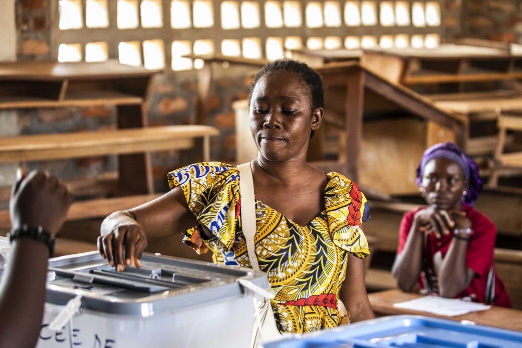 Un électeur dépose un bulletin dans une urne.