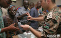 Free medical consultation given by UNOCI Jordanian Contingent in  Marcory: A peacekeeper explains to a woman the correct dosage of a drug (Abidjan, November 2007)