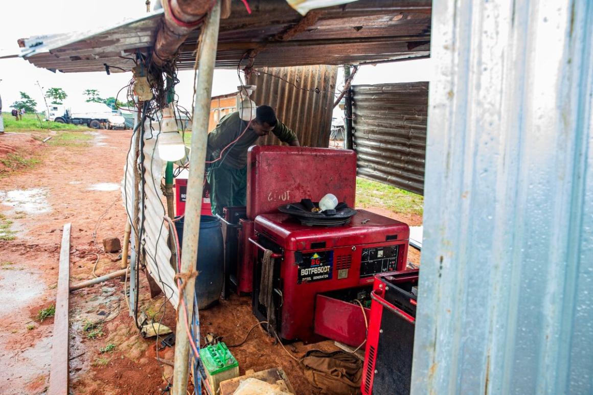 An individual installs electrical equipment outside.